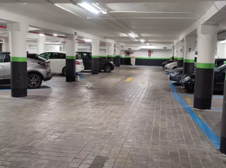 Parking Estación de Atocha pasillo con plazas de aparcamientos ocupadas en los dos lados, hay coches grandes y coches medianos.