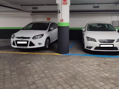 Plazas de aparcamiento en Parking Garaje Ronda de Atocha con dos coches aparcados ensenando el ancho de las plazas. 